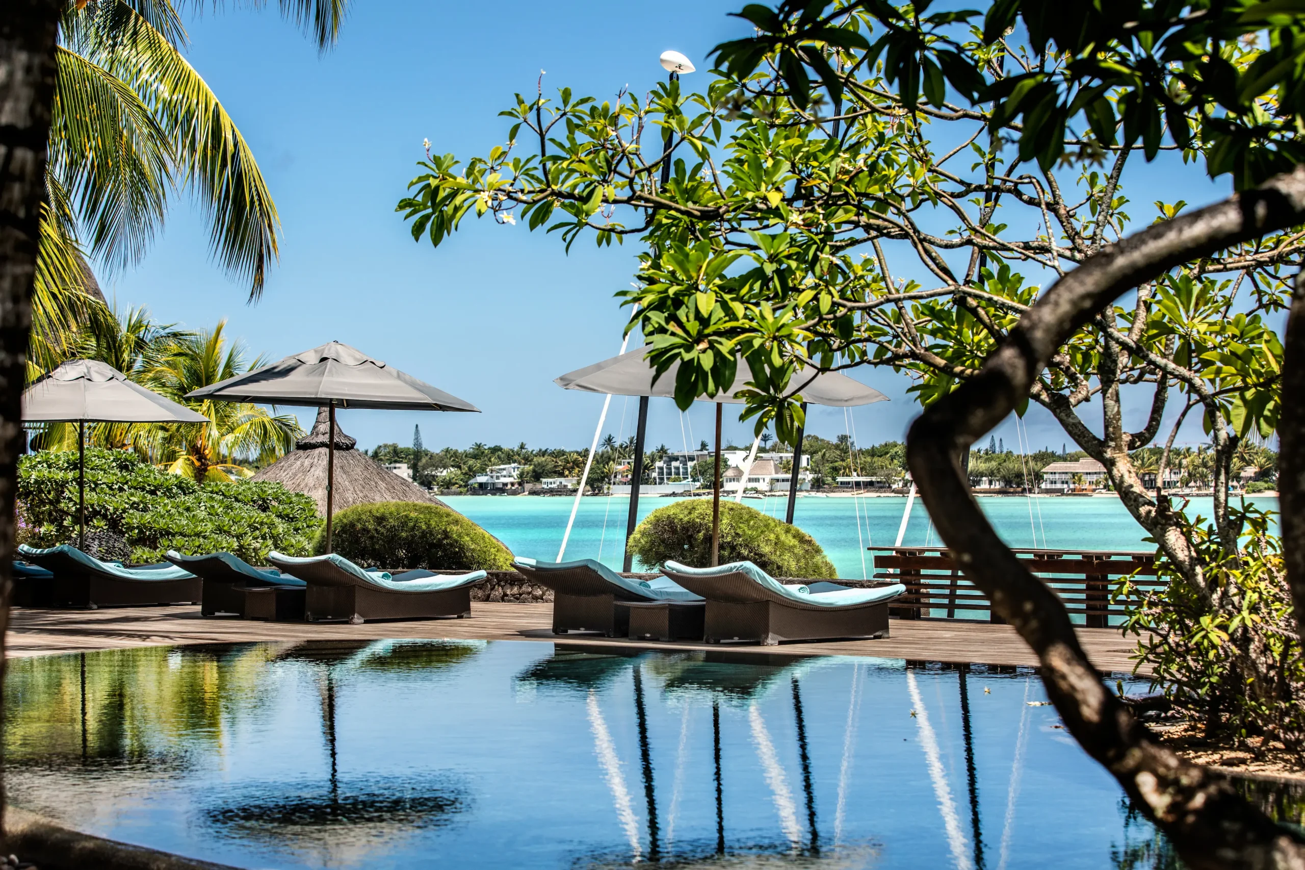 royal palm beachcomber mauritius luxury swimming pool surrounded by tropical gardens and elegant sun loungers