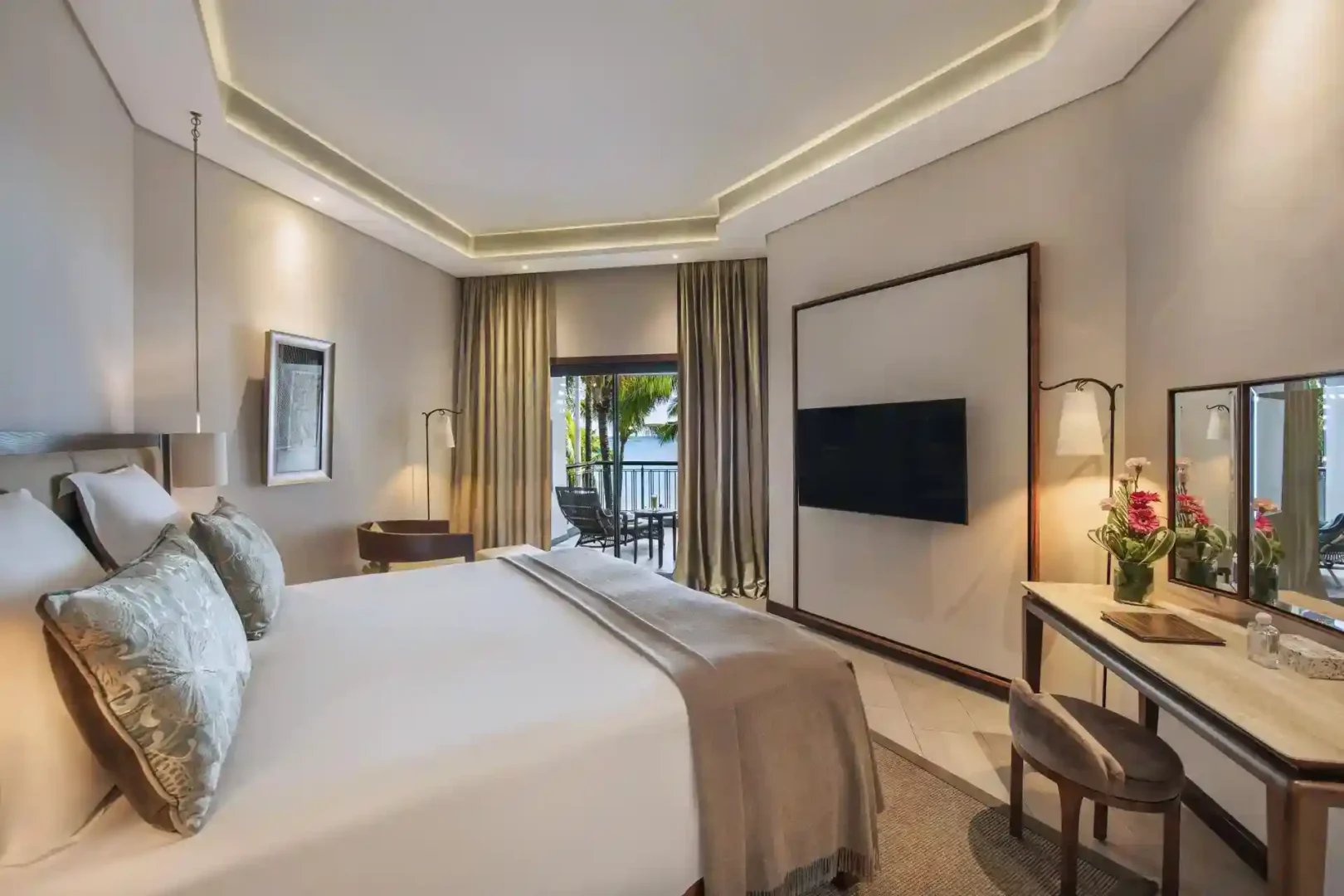 royal palm presidential suite bedroom with king-size bed, nightstands, lamps, and seating area
