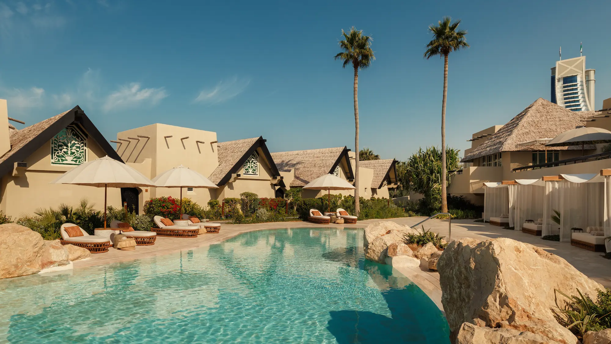 al bahar villas landscape pool at Jumeirah Beach Hotel with private cabanas, sun loungers and lush garden surroundings creating a relaxed beachfront resort atmosphere