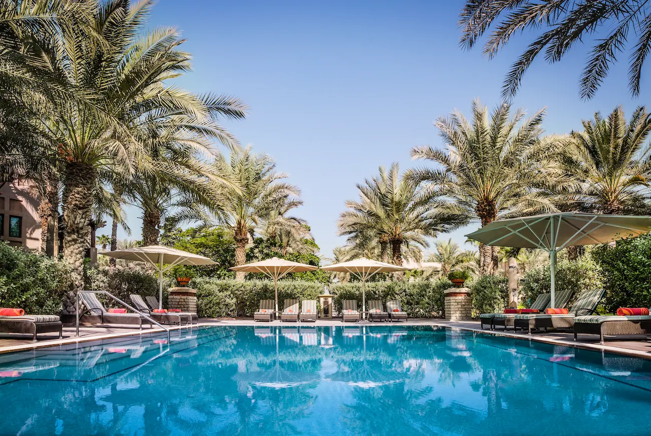 private pool at arabian house in jumeirah dar al masyaf surrounded by lush gardens and traditional arabian architecture