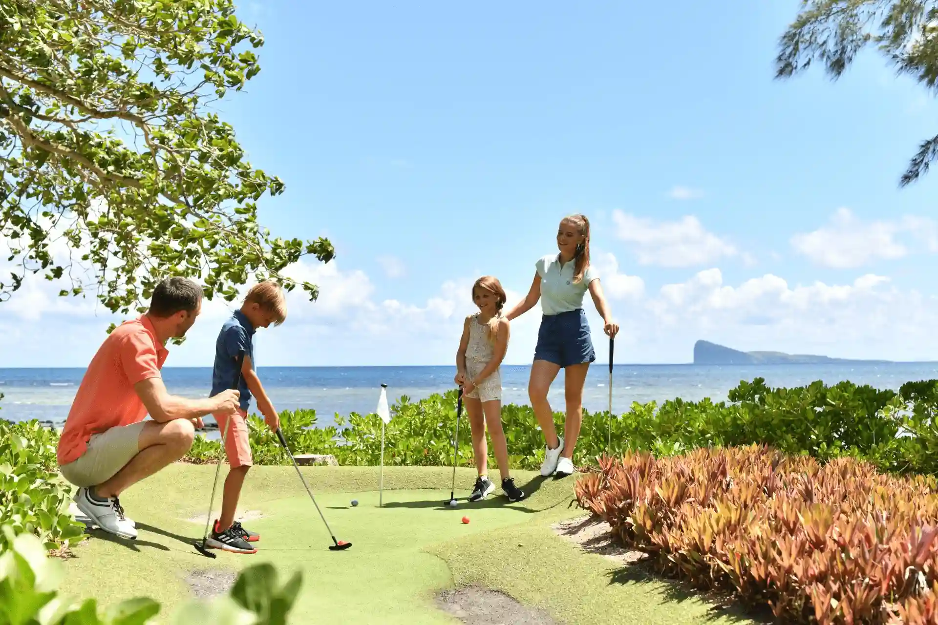 golfers playing on lush green cannonier mauritius golf course with ocean view