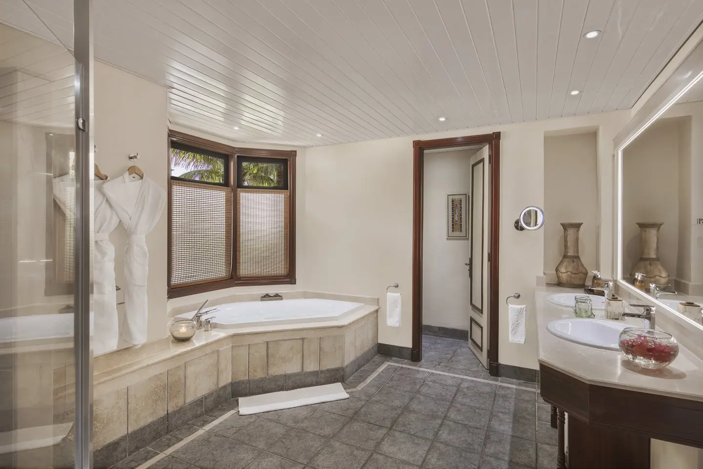 dinarobin senior suite bathroom with large bathtub, walk-in shower, and luxurious marble finishes