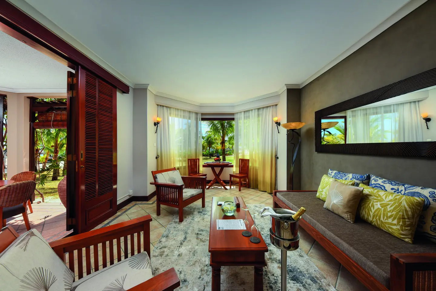 dinarobin senior suite lounge area with sofa, coffee table, and tropical-themed decor