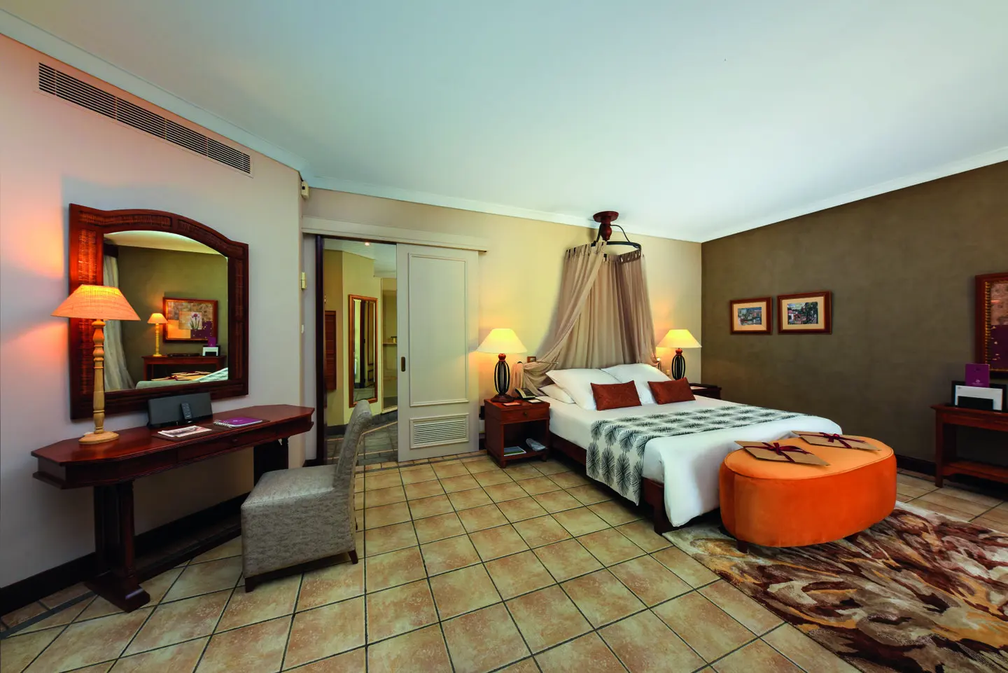 dinarobin senior zen suite room with king bed, modern tropical decor, and seating area