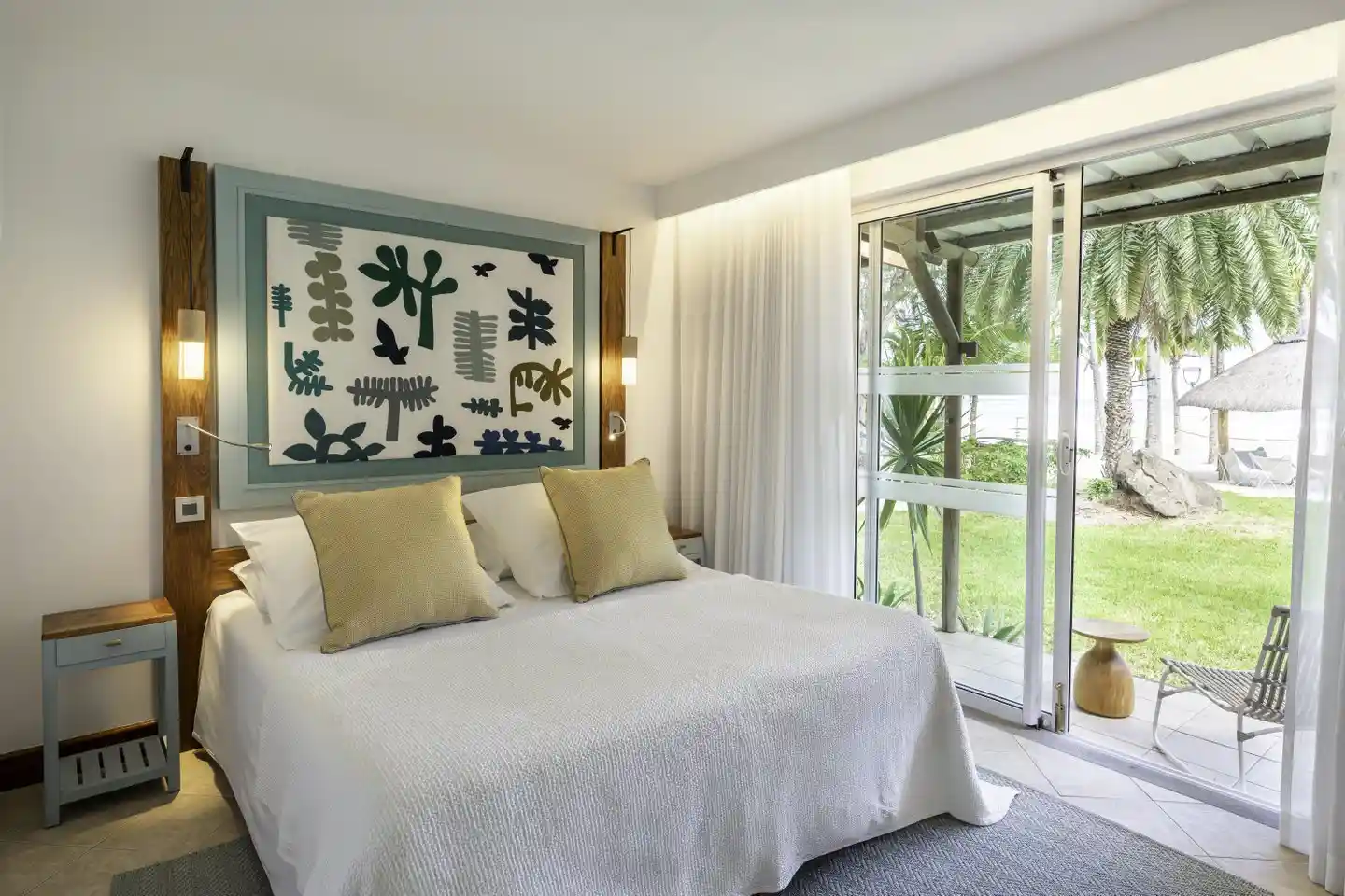 dinarobin villa bedroom with king bed, elegant tropical decor, and seating area