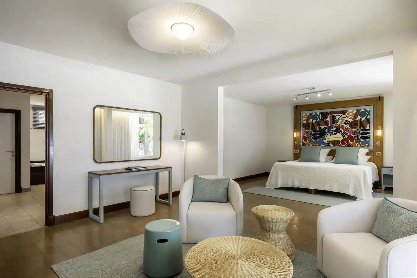 dinarobin villa bedroom with king bed, tropical decor, and large windows overlooking the garden