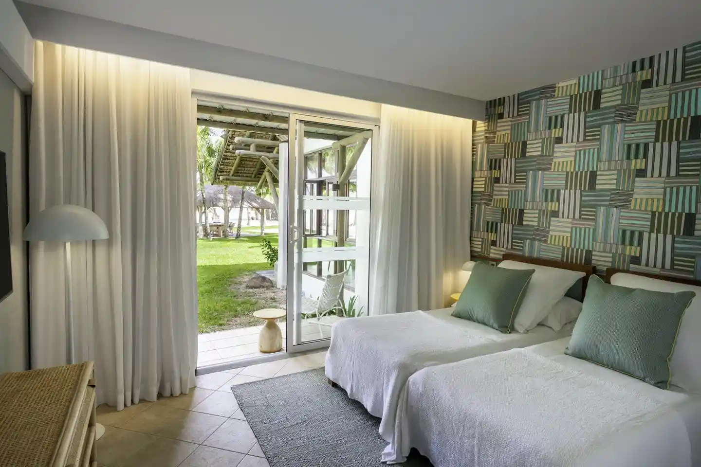 dinarobin villa bedroom with single beds, modern decor, and garden view