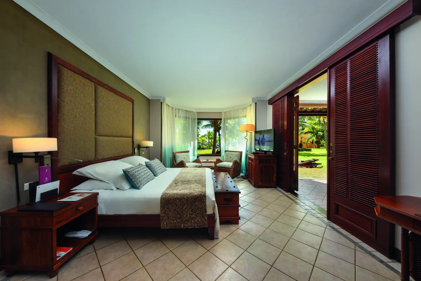 dinarobin zen suite beachfront bedroom with garden view, king bed, and tropical decor