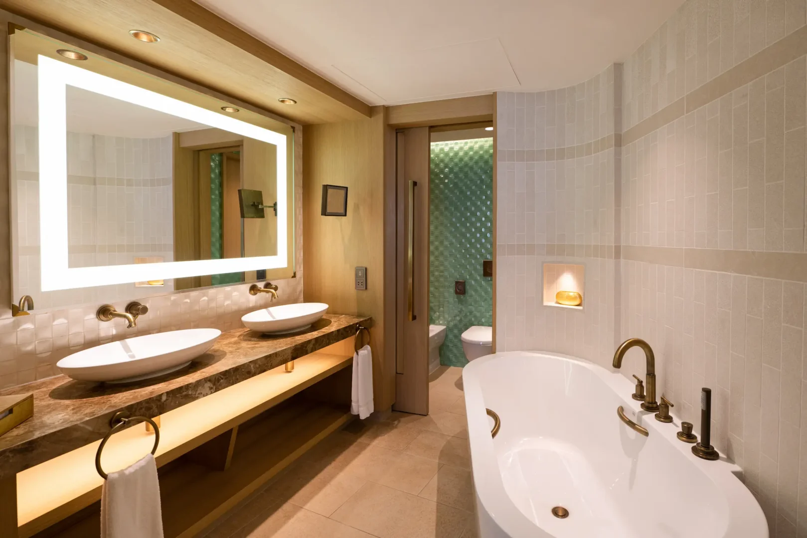 bathroom in family garden suite at Jumeirah Beach Hotel with modern fittings, bathtub and garden views