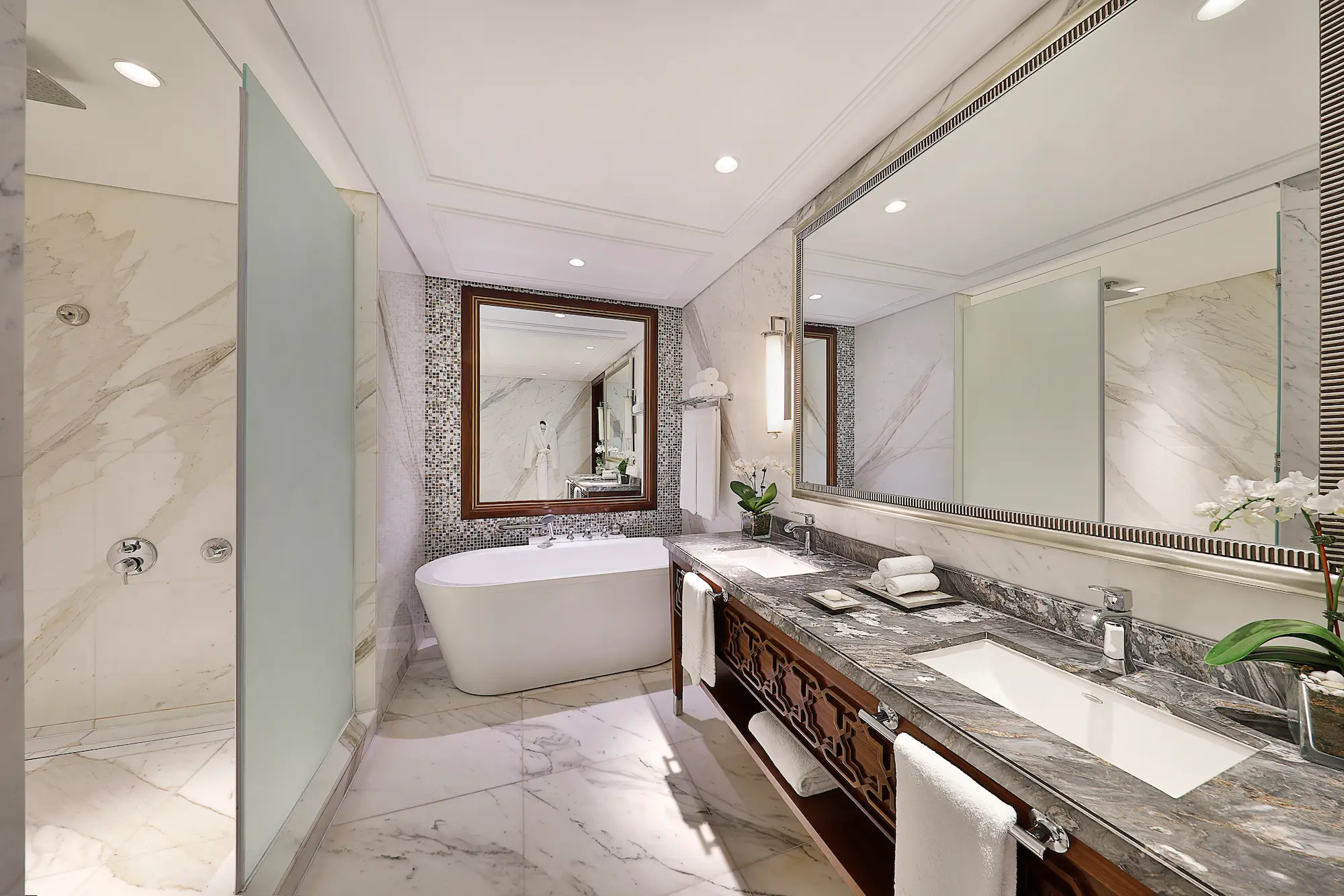 bathroom in family suite at the ritz-carlton dubai jbr featuring marble finishes, deep soaking bathtub, walk-in shower, and luxury amenities in dubai marina