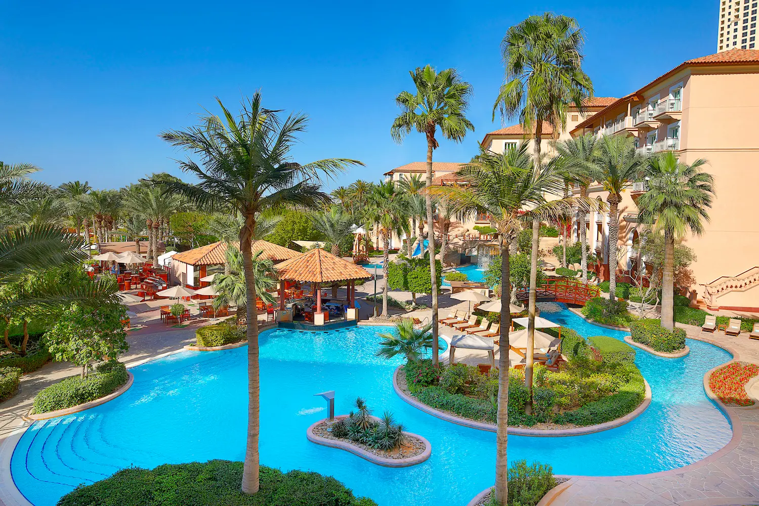 ghoroob pool view at the ritz-carlton dubai jbr featuring tranquil swimming pool, palm lined surroundings, and relaxed luxury resort atmosphere in dubai marina