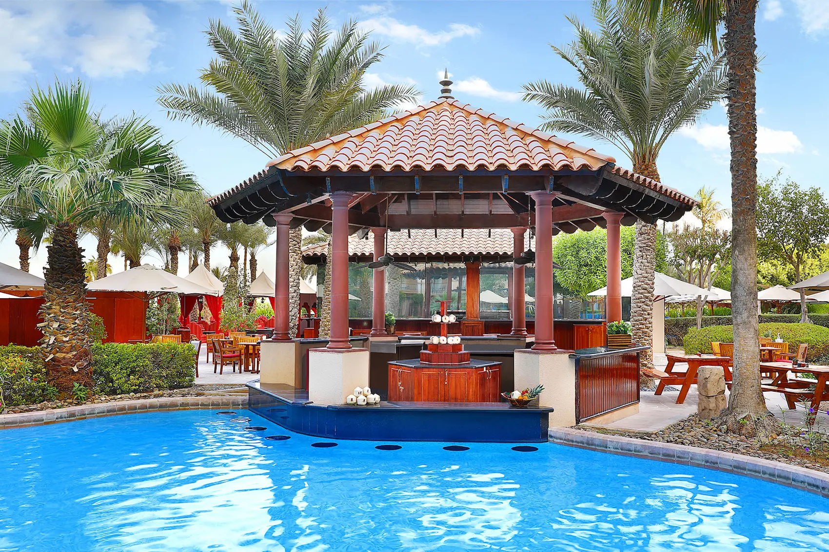gulf pavilion pool bar at the ritz-carlton dubai jbr featuring swim up bar seating, relaxed poolside atmosphere, and views towards the arabian gulf in dubai marina