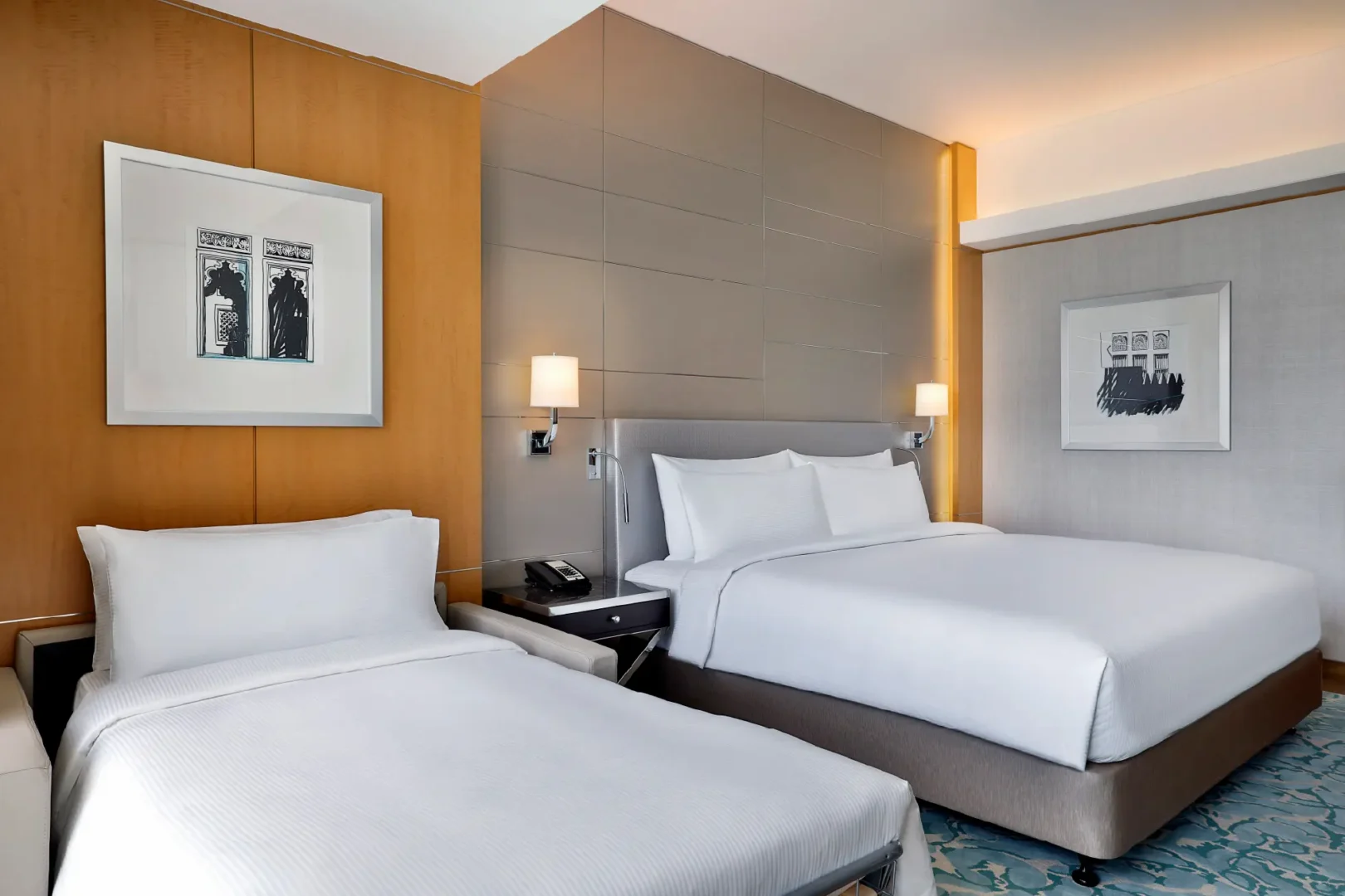 twin guest room at Hilton Dubai Palm Jumeirah featuring contemporary design, two beds, bedside lighting and framed artwork