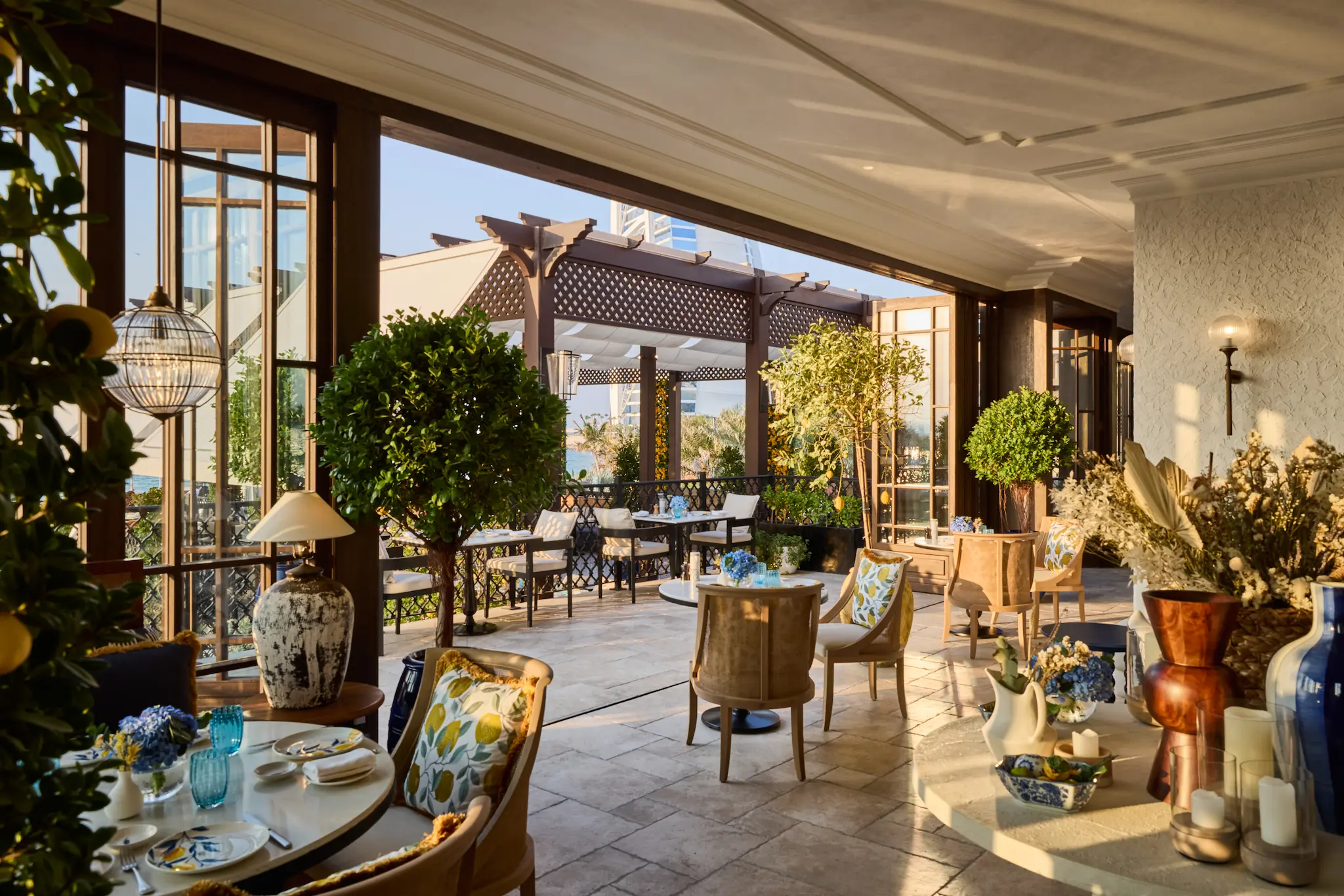 cala vista indoor terrace at jumeirah mina al salam dubai featuring bright mediterranean-inspired interiors, elegant dining tables and floor-to-ceiling windows overlooking the resort landscape