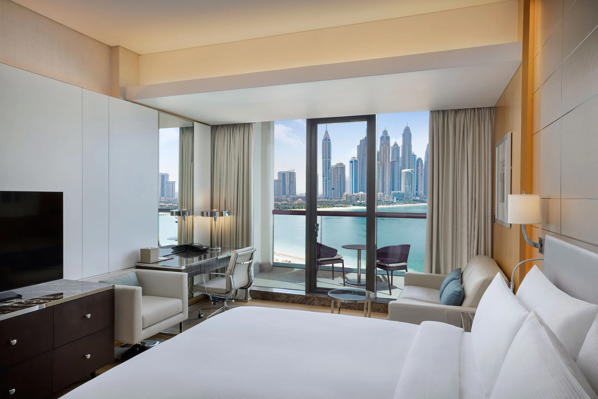 king deluxe room with sea view and balcony featuring plush bed, contemporary interiors and private outdoor seating overlooking the ocean