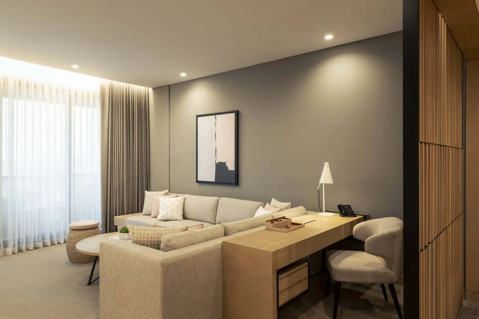 club suite work desk at le royal meridien beach resort and spa dubai featuring modern workspace, comfortable chair and large windows with views of the resort gardens and arabian gulf