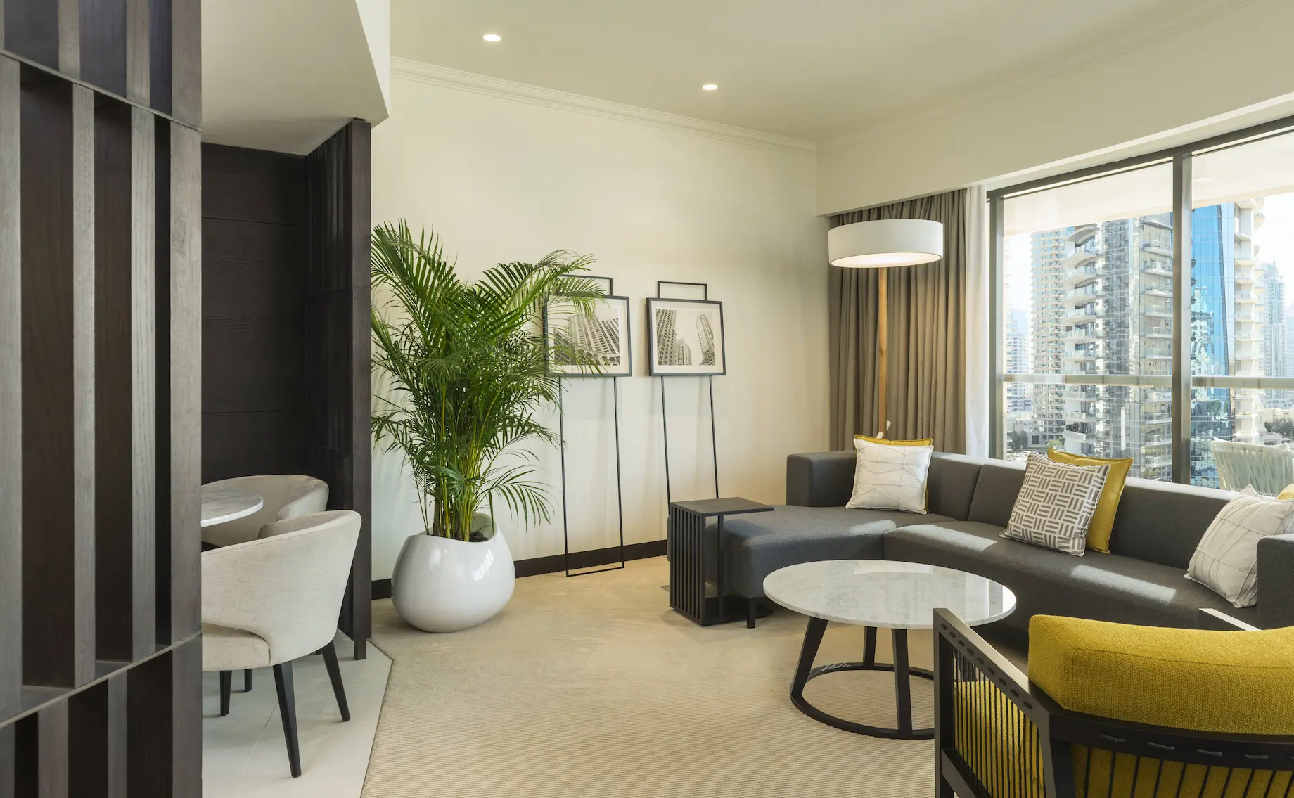 deluxe suite living area at le royal meridien beach resort and spa dubai featuring spacious seating, modern décor, coffee table and large windows with views of the arabian gulf or resort gardens