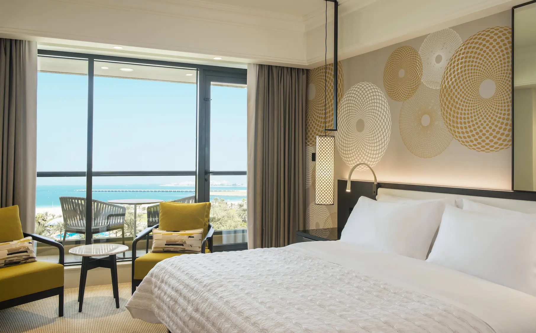 king size bed sea view bedroom at le royal meridien beach resort and spa dubai featuring contemporary décor, plush bedding and floor-to-ceiling windows overlooking the arabian gulf