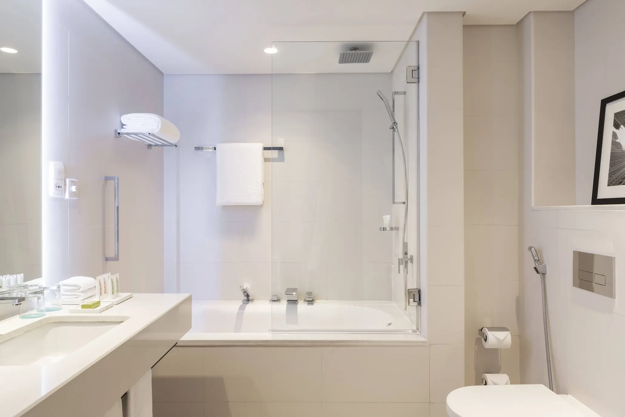 main deluxe bathroom at le royal meridien beach resort and spa dubai featuring marble finishes, walk-in shower, vanity area and modern fixtures