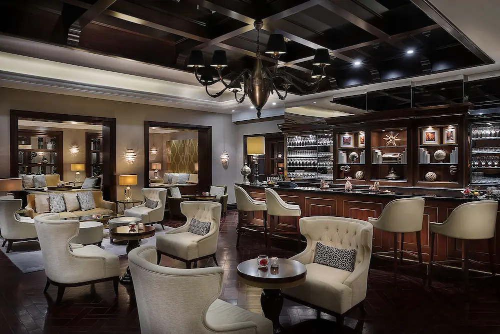library bar overview at the ritz-carlton dubai jbr featuring sophisticated lounge seating, dark wood interiors, and refined cocktail atmosphere in dubai marina