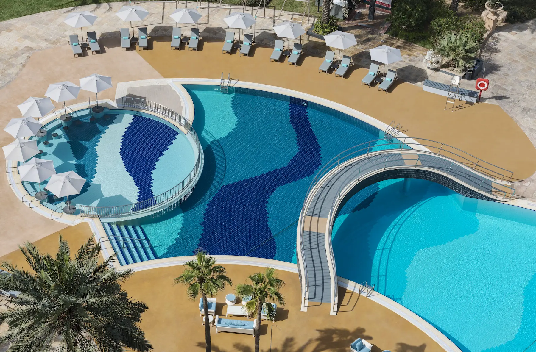 main outdoor pool at le royal meridien beach resort & spa dubai with sun loungers, landscaped surroundings, and luxury beachfront setting