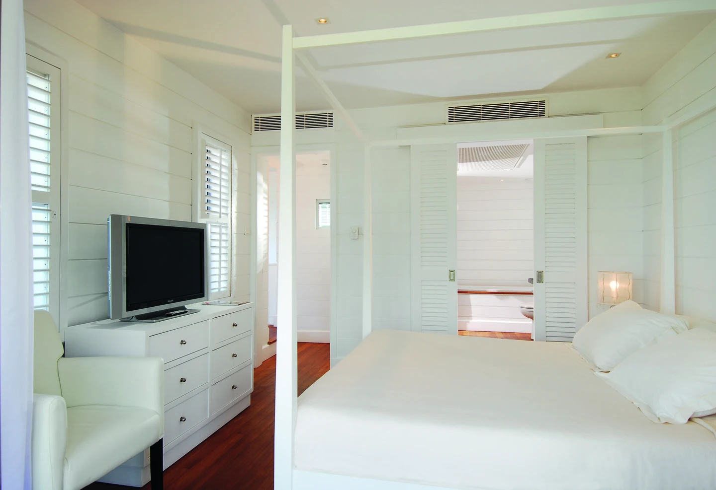 mauricia suite bedroom with king size bed, seating area, and tropical resort views