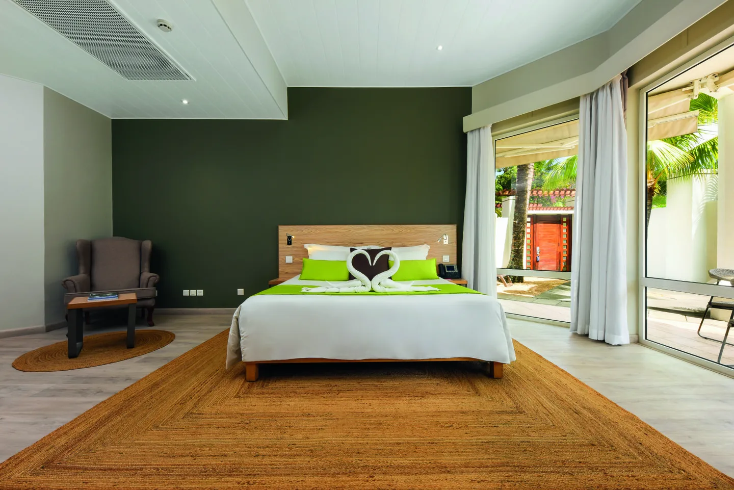 mauricia villa bedroom with large windows overlooking tropical gardens and pool
