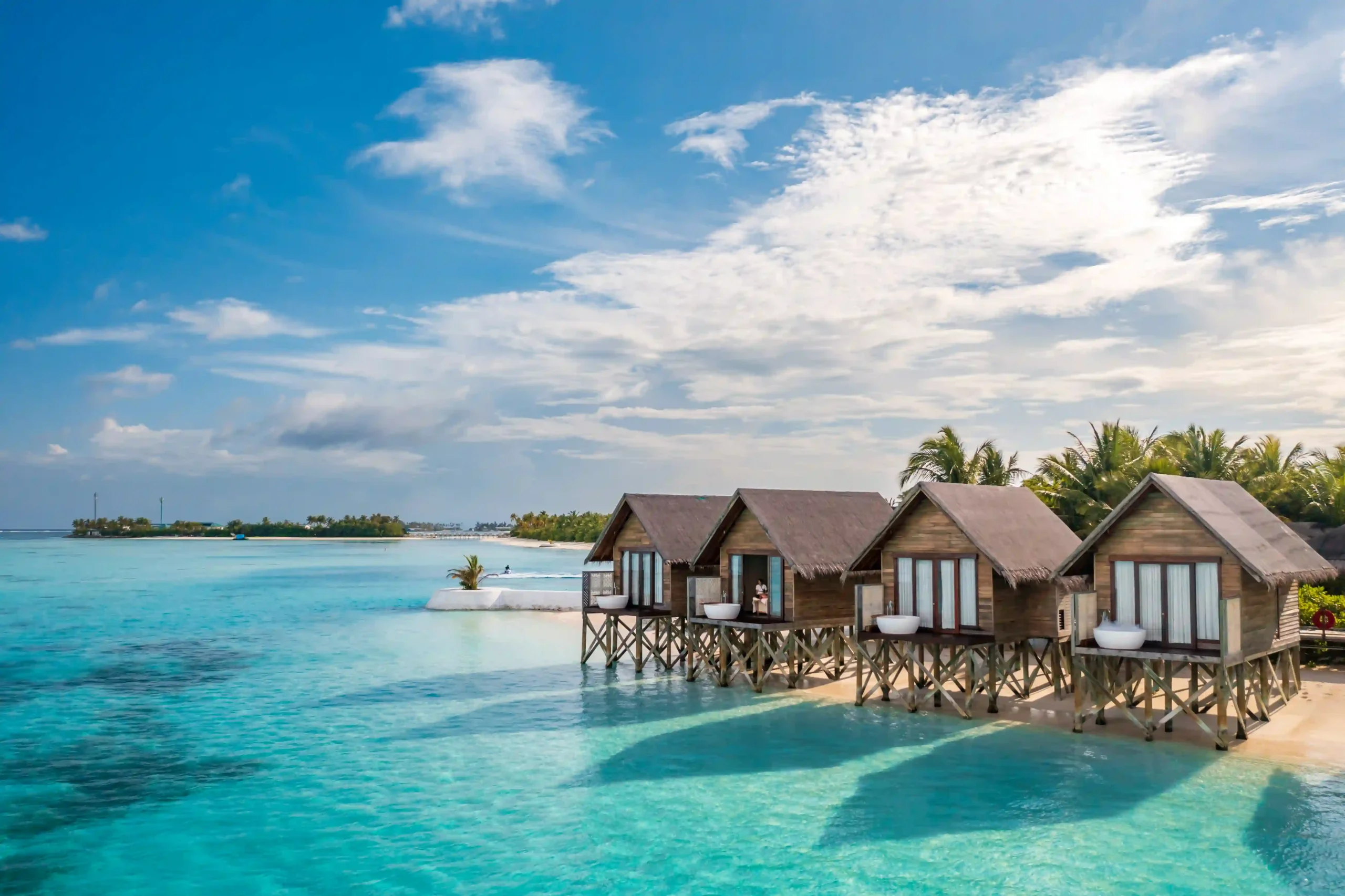 aerial view of ozen life maadhoo maldives resort featuring overwater villas, turquoise lagoon, and white sandy beaches