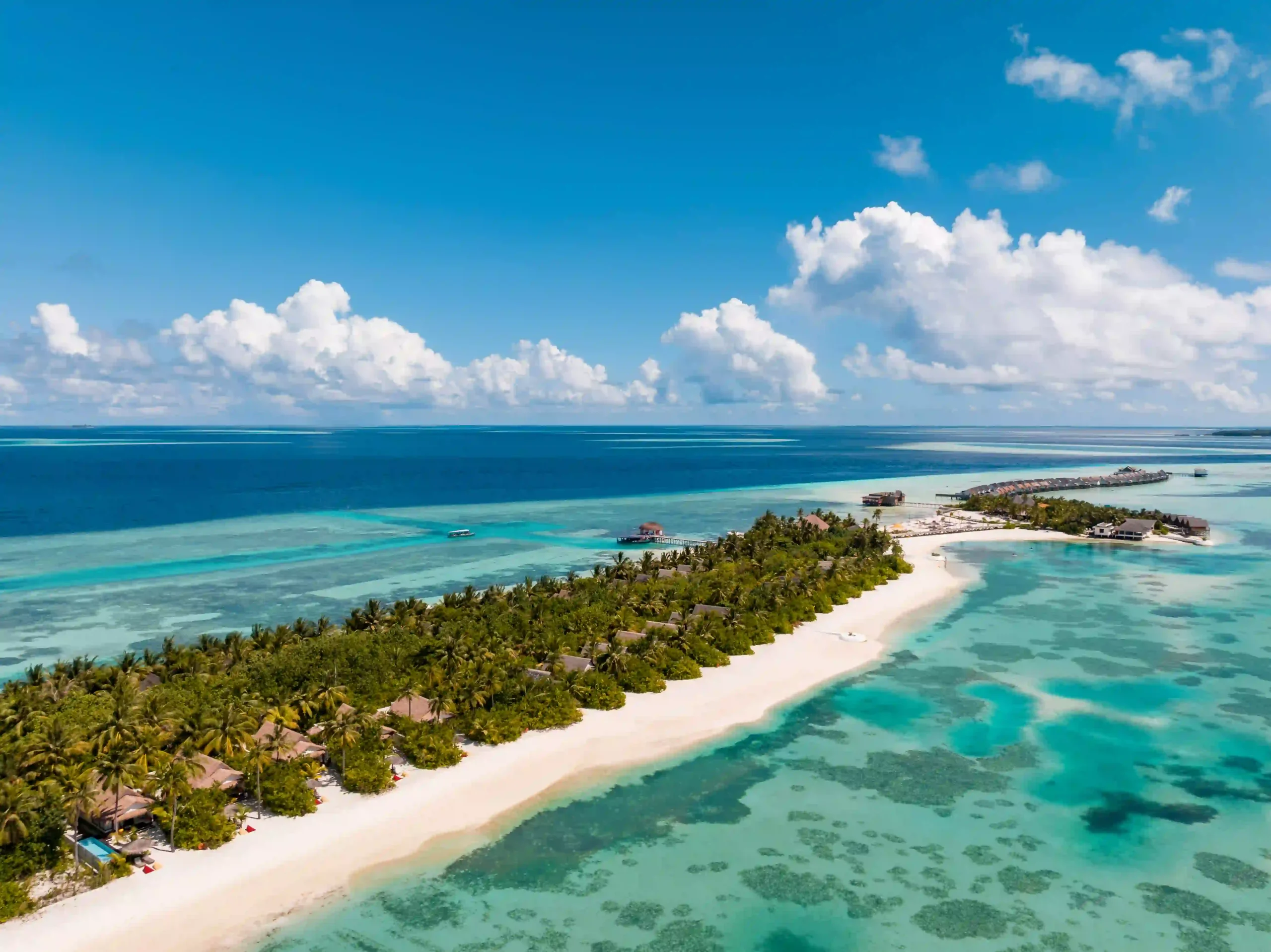 aerial view of ozen life maadhoo island in the maldives surrounded by turquoise lagoon and white sandy