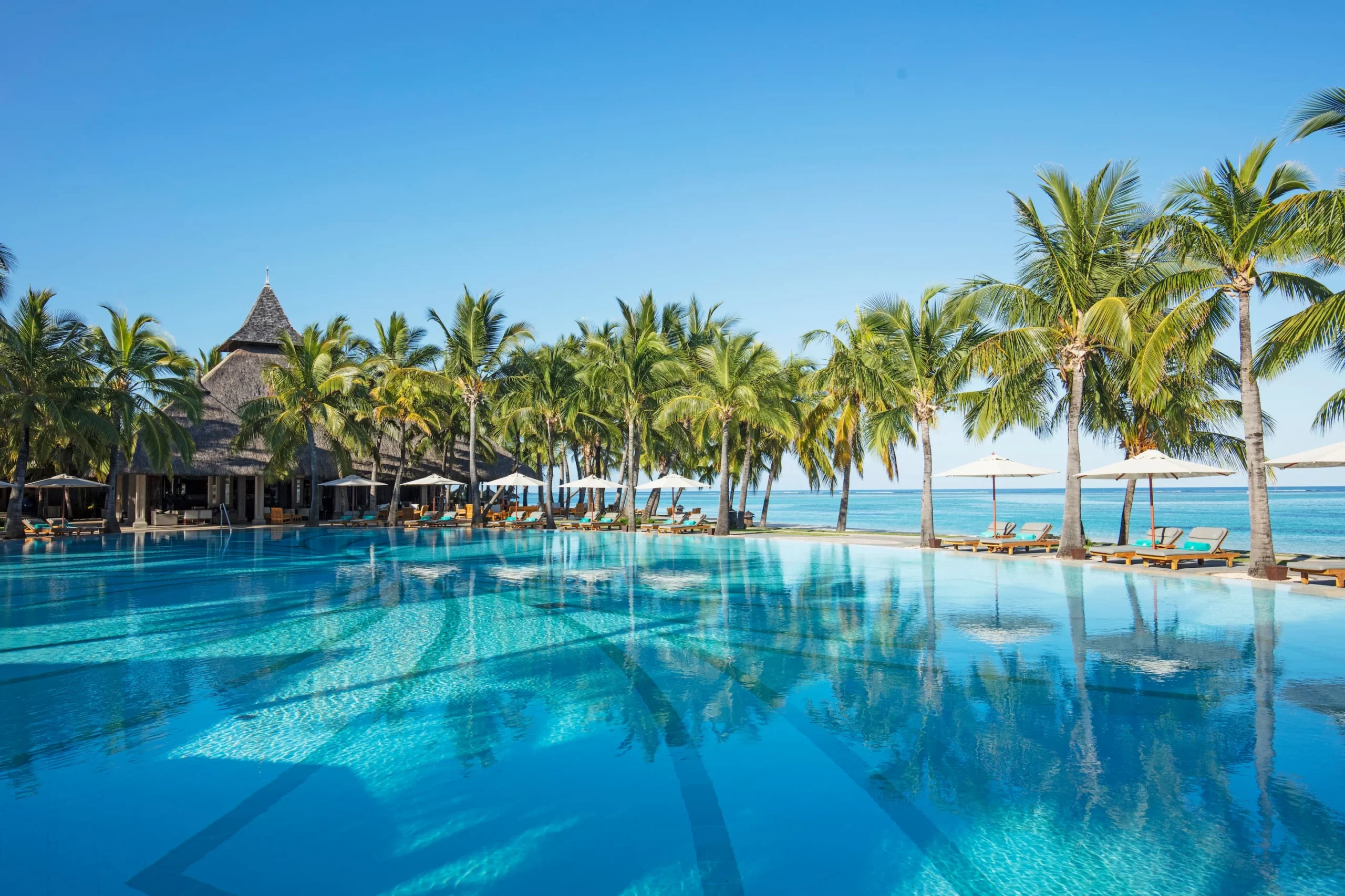 paradis beachcomber mauritius exterior pool surrounded by tropical gardens with views across the resort coastline