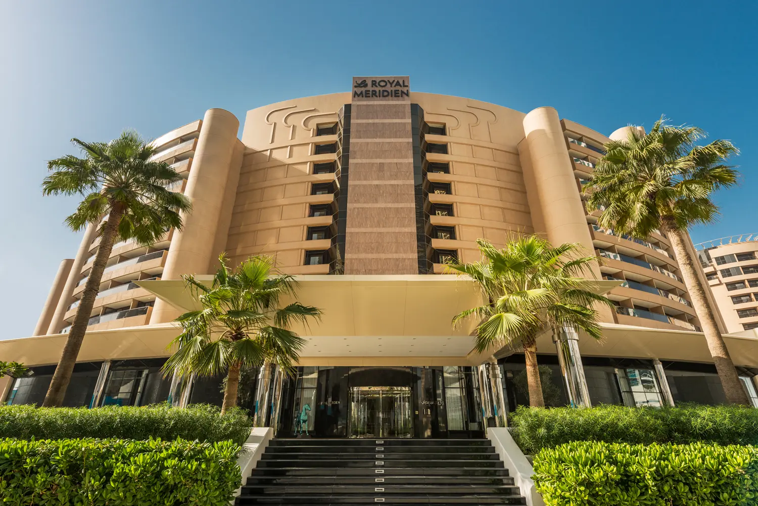 daytime exterior view of le royal meridien beach resort & spa dubai with landscaped gardens, luxury architecture, and beachfront setting