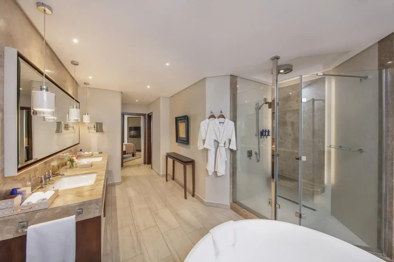 royal palm penthouse suite bathroom with bathtub, shower, double vanity, and modern fixtures
