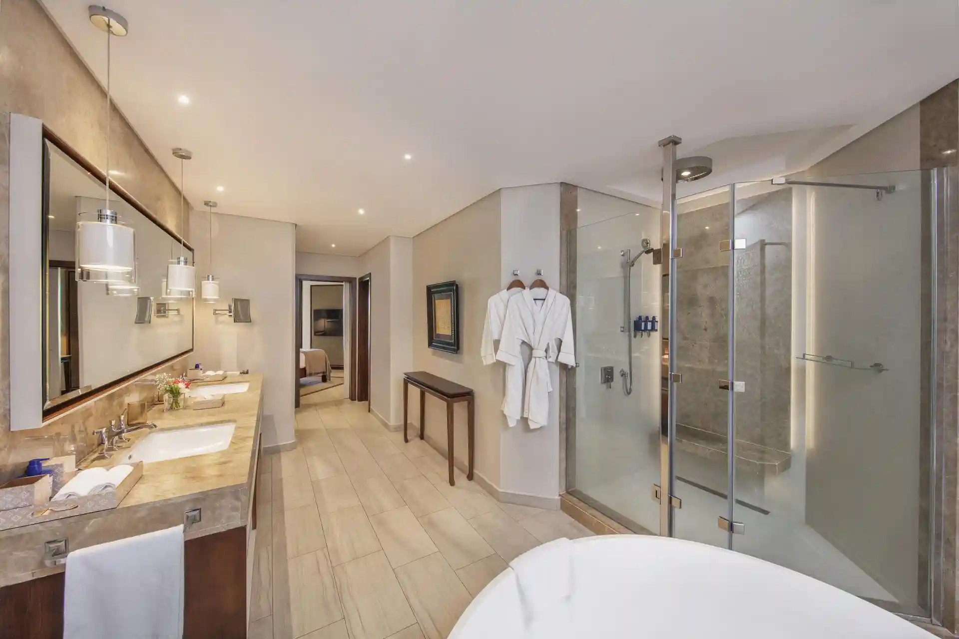 royal palm penthouse suite bathroom with bathtub, shower, double vanity, and modern fixtures