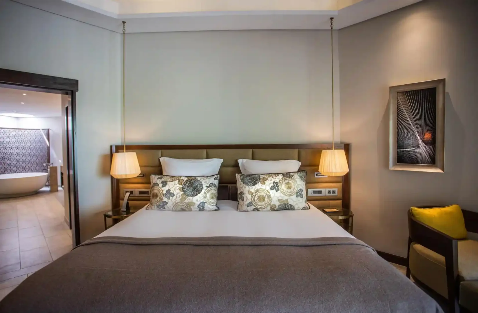 royal palm penthouse suite bedroom with attached bathroom, including shower, bathtub, and vanity area