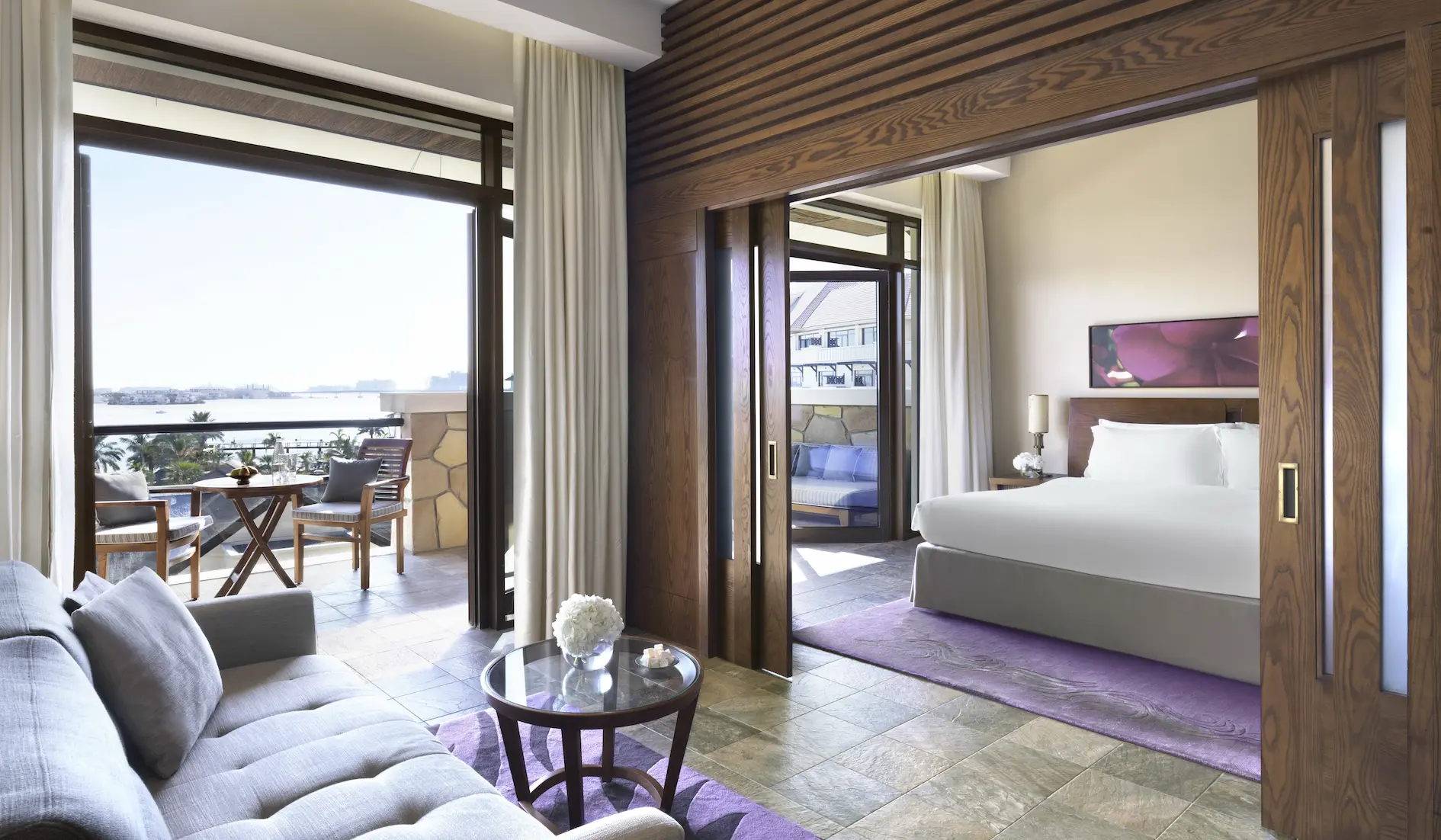 junior suite at sofitel dubai the palm with modern decor, king bed, spacious living area, and private balcony with sea or resort views