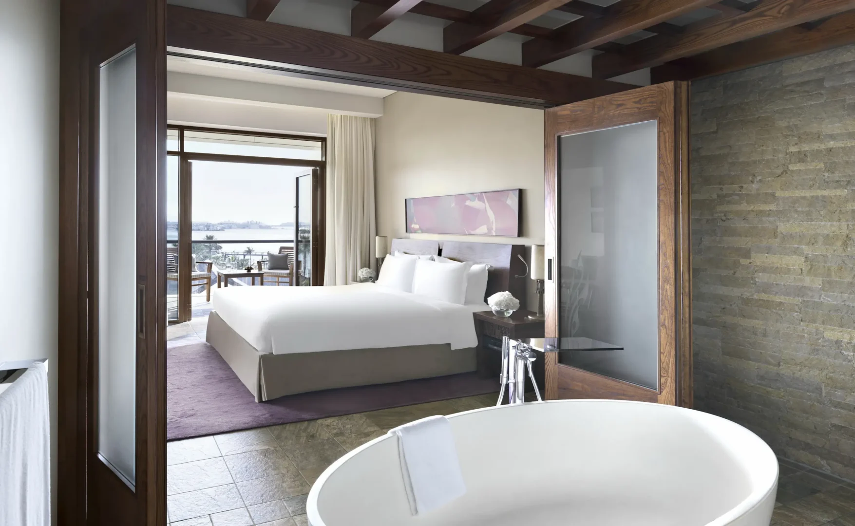 junior suite at sofitel dubai the palm with sea view, modern decor, king bed, spacious living area, and private balcony overlooking the Arabian Gulf