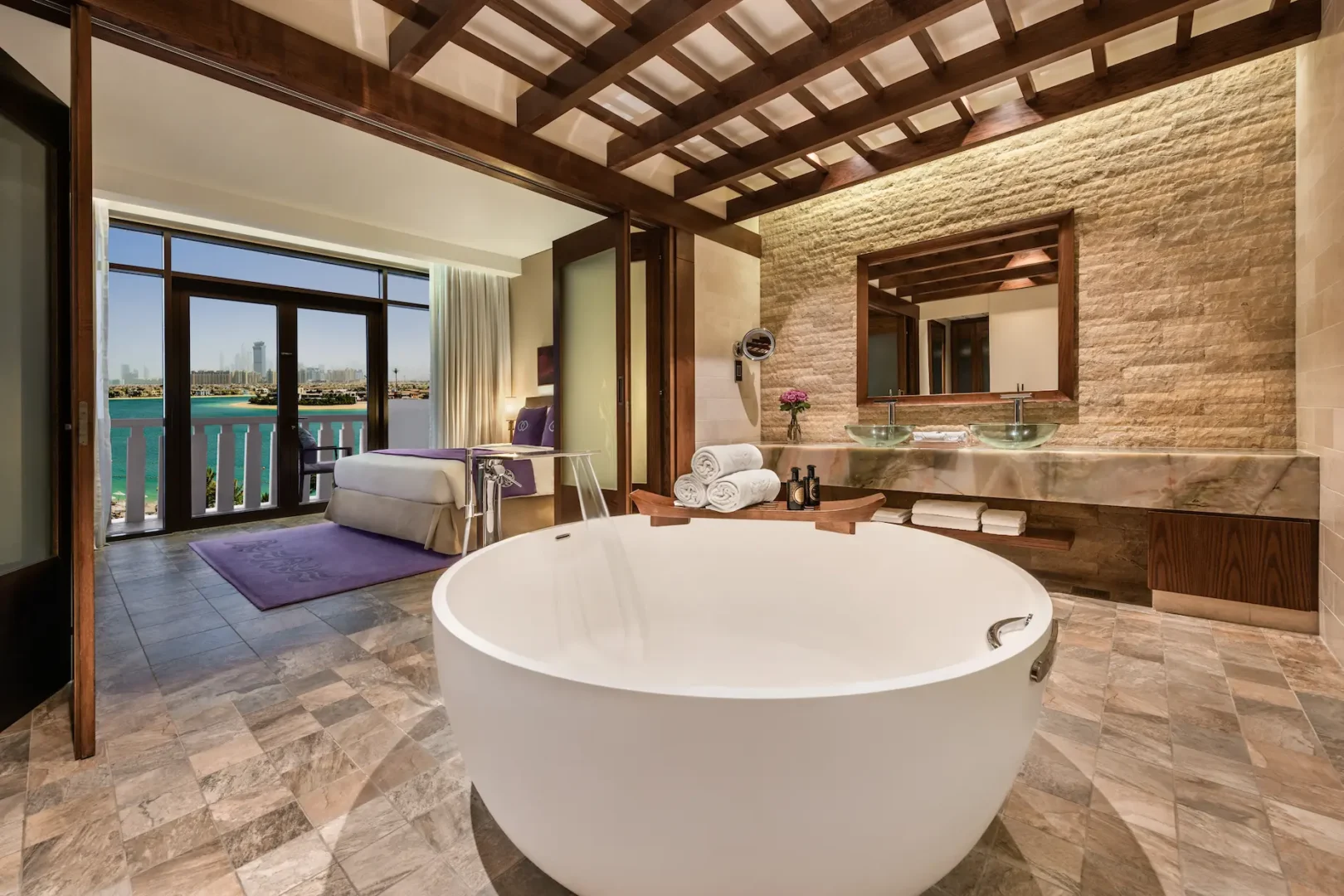 bathroom in prestige suite at sofitel dubai the palm featuring modern design, double sinks, walk-in shower, bathtub, and luxurious fixtures