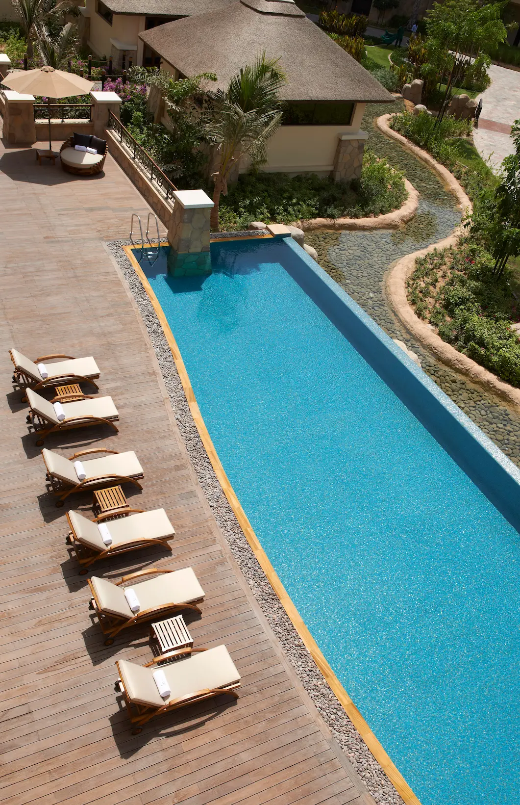 outdoor swimming pool at so spa, sofitel dubai the palm with loungers, tropical landscaping, and serene wellness setting