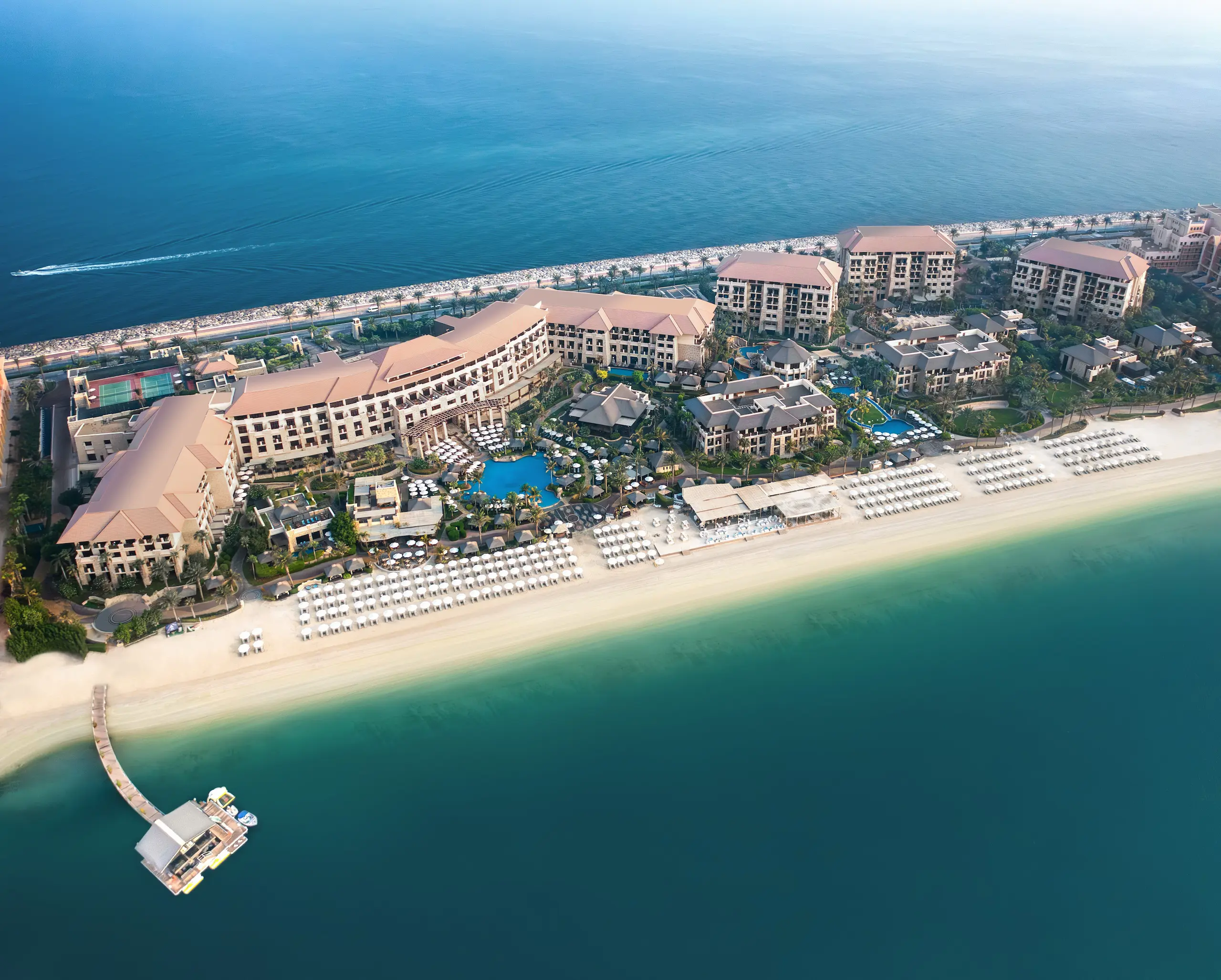 aerial view of sofitel dubai the palm on palm jumeirah showing beachfront location, tropical gardens, and resort pools overlooking the arabian gulf