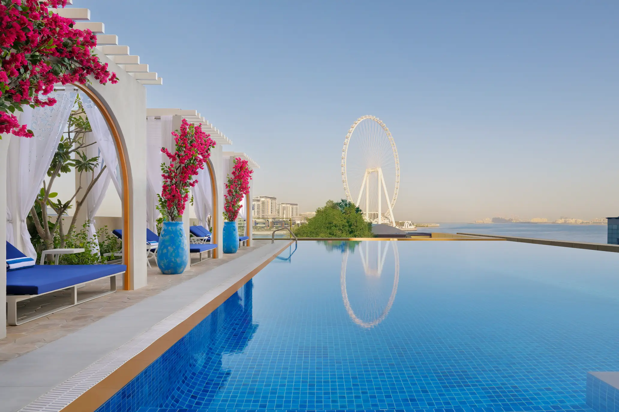 swimming pool view at ja ocean view hotel with arabian gulf and palm jumeirah backdrop