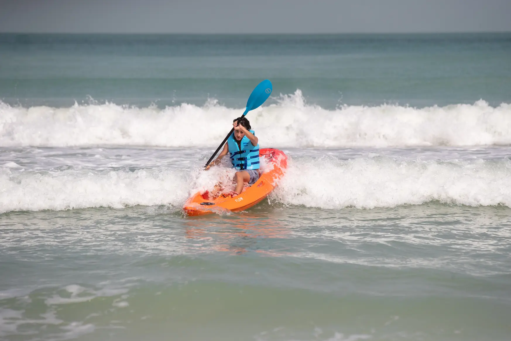 teenagers enjoying watersports activities with life jackets on a sunny beach setting
