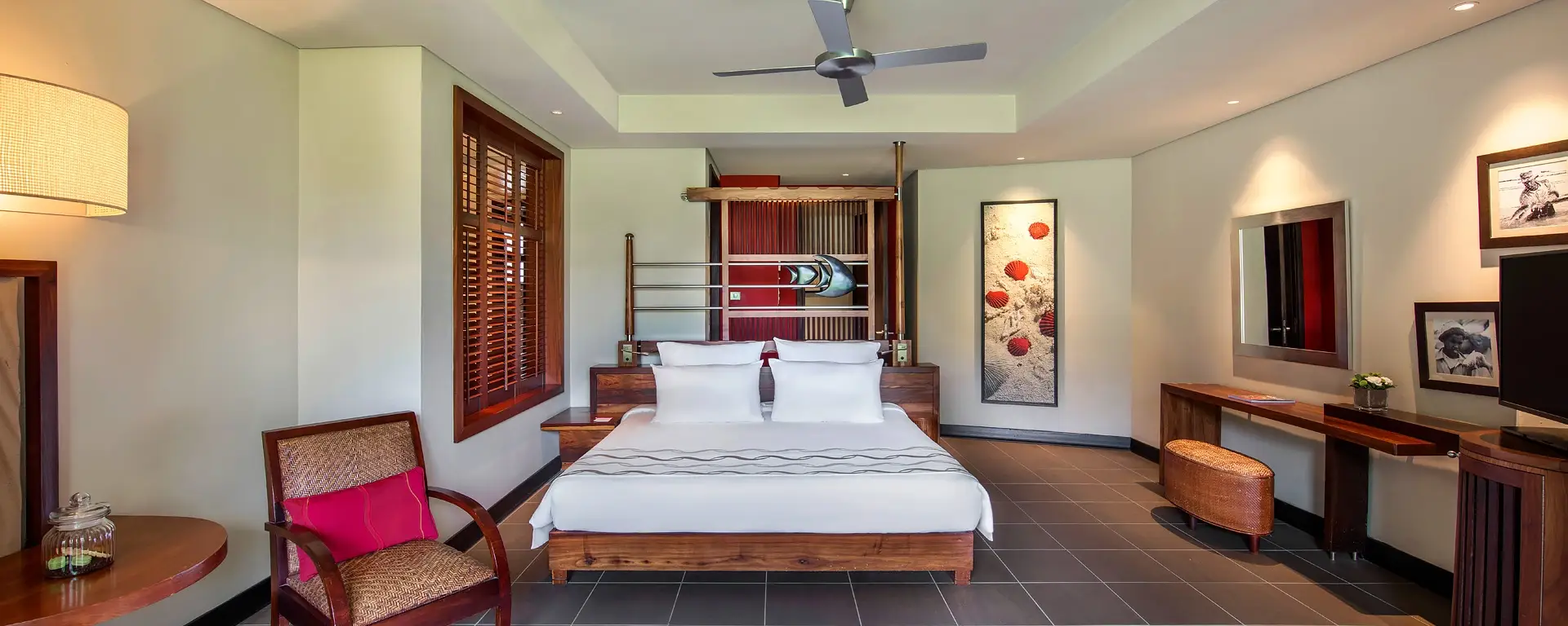trou aux biches 2 bedroom family suite bedroom with two beds, elegant decor, and large windows with natural light