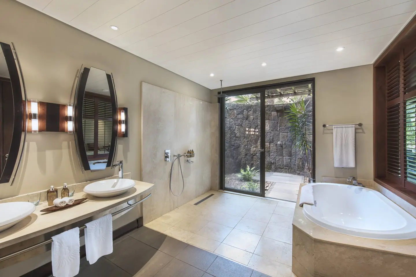 trou-aux-biches junior suite tropical bathroom with modern fixtures, spacious shower, and natural light with tropical views