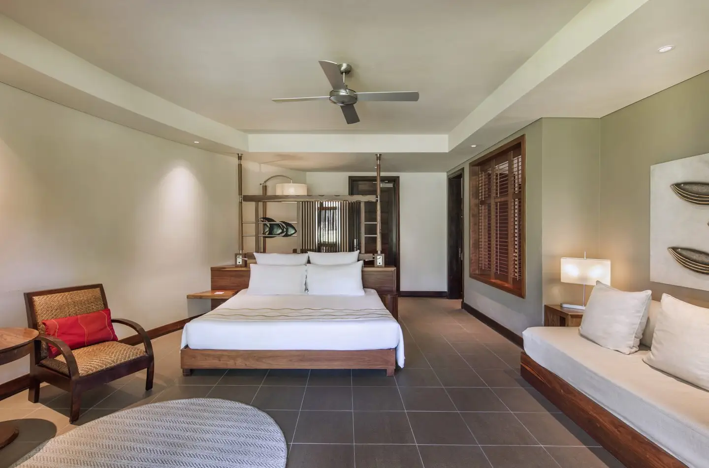 trou-aux-biches junior suite tropical bedroom with king-size bed, tropical decor, and large windows overlooking greenery