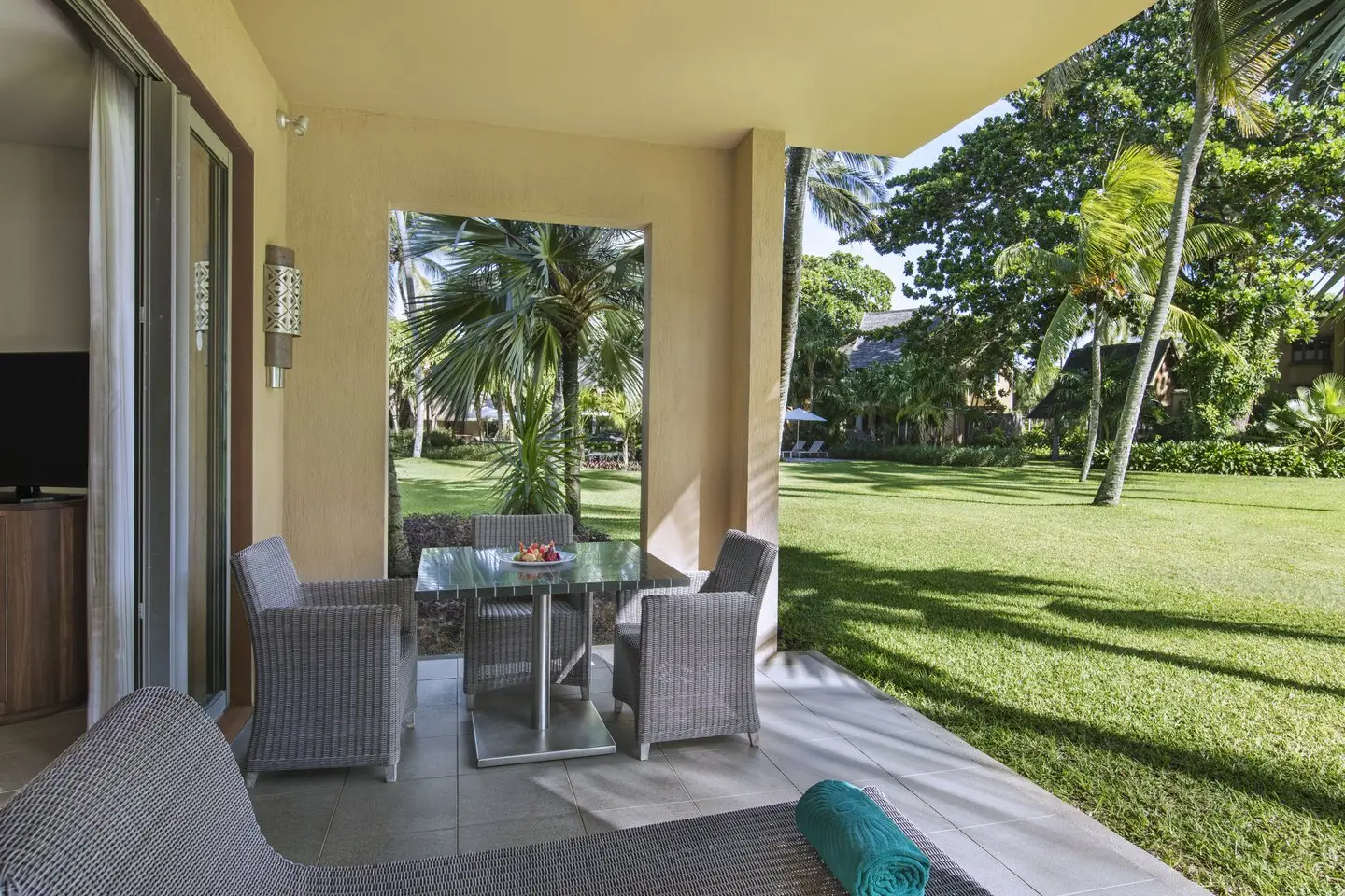 trou-aux-biches junior suite tropical outside terrace with lounge chairs, ocean view, and lush palm trees