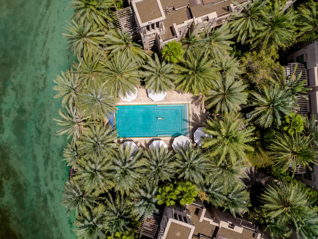 aerial drone view of villa cluster pools at jumeirah dar al masyaf with lush landscaping and resort-style lifestyle setting