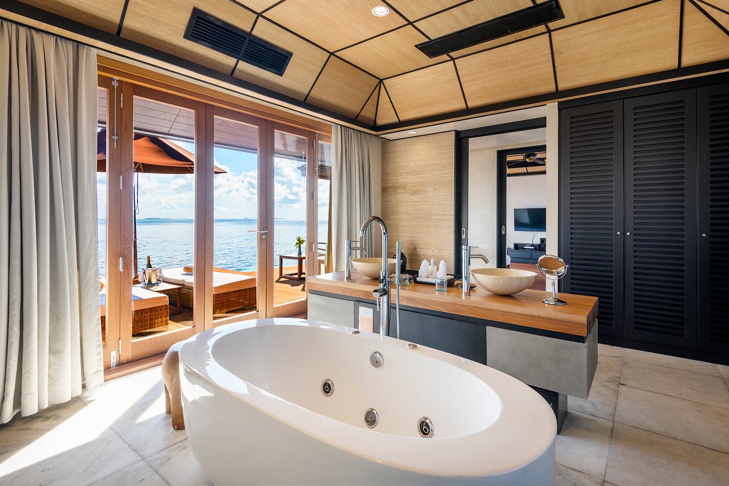 lily beach maldives deluxe water villa bathtub with view overlooking the calm lagoon with serene ocean scenery and elegant tropical luxury