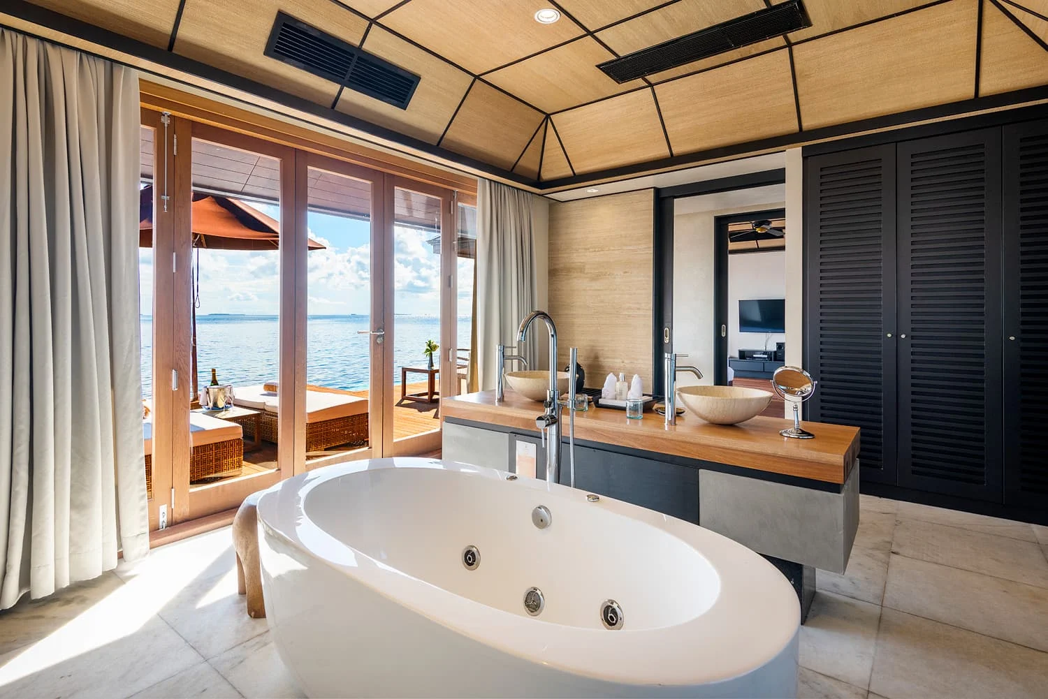 lily beach maldives deluxe water villa bathtub with view overlooking the calm lagoon with serene ocean scenery and elegant tropical luxury