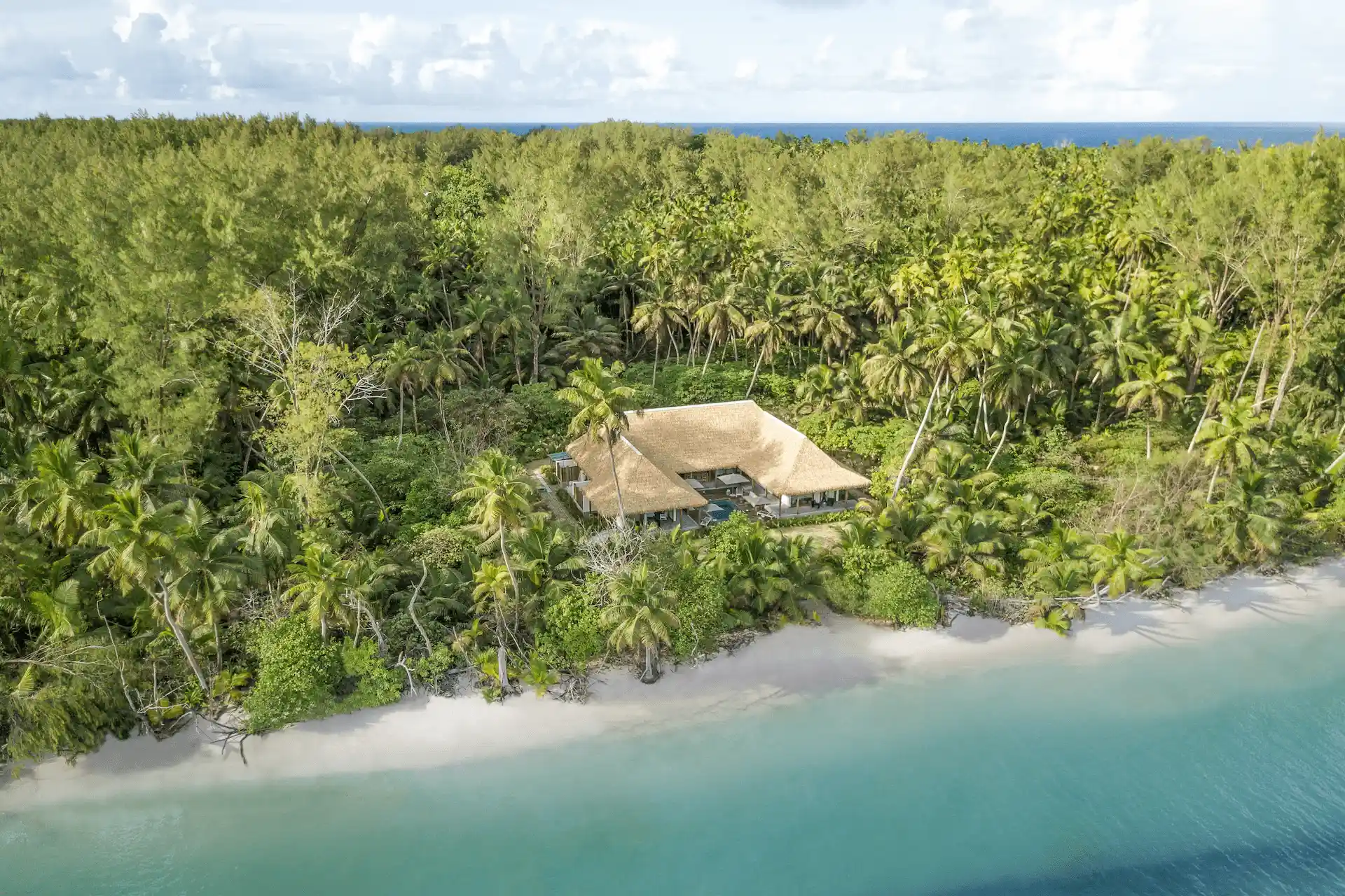 alphonse island seychelles the beach retreat aerial view with private terraces, turquoise ocean, and surrounding tropical vegetation