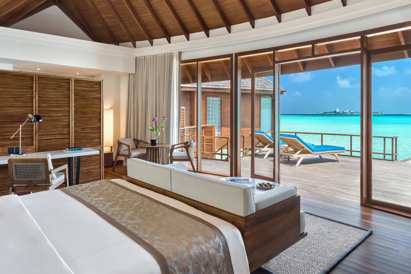 anantara dhigu maldives resort sunrise over water villa bedroom angle